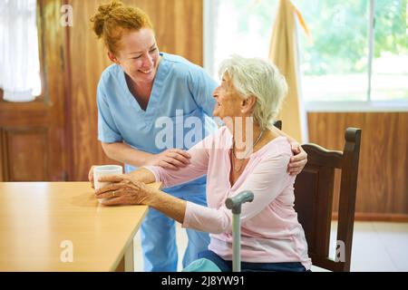 Die ältere Krankenschwester kümmert sich sorglos um die ältere Frau im Pflegeheim Stockfoto