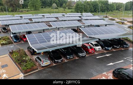 Luftaufnahme über innovativen Solarzellen auf einem Parkplatz Dächer, die gute Nutzung von kleinen Raum in einer Stadt zum Laden von Elektroautos Stockfoto