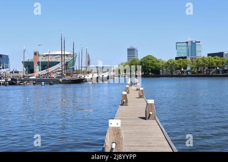 Anlegestelle am Fluss IJ mit Wissenschaftsmuseum Nemo in Amsterdam, Niederlande Stockfoto