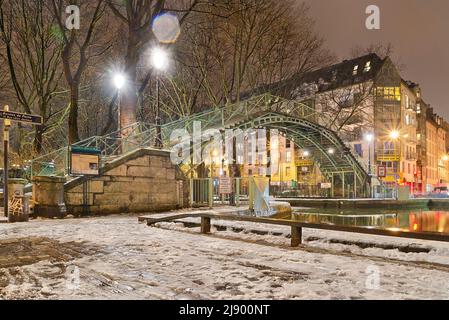 La passerelle du Temple, eine Fußgängerbrücke über den Canal Saint-Martin in einem Schneesturm, vom Quai de Jemmapes aus gesehen. Stockfoto