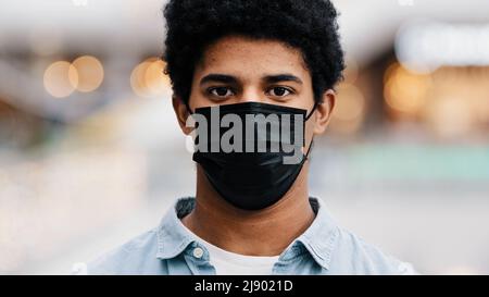 Porträt männlich maskiertes Gesicht afroamerikanischer Mann nimmt medizinische Maske lächelnd Blick auf Kamera Relief Ende des Coronavirus beenden Pandemie erholen Stockfoto