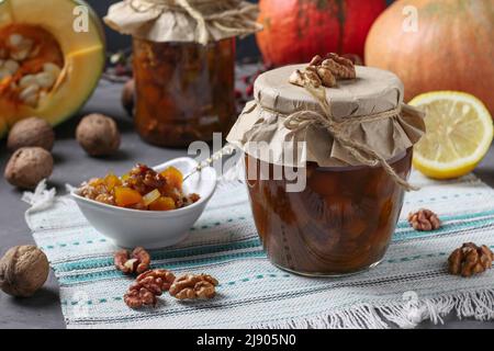 Hausgemachte Kürbiskonfitüre mit Zitrone und Walnüssen in Gläsern und Schüssel Stockfoto