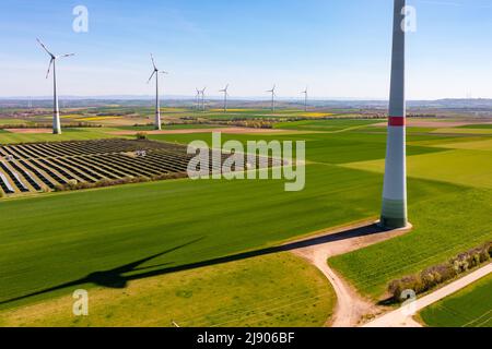 Luftaufnahme von Windturbinen und Sonnenkollektoren eines Solarparks zwischen Feldern in Rheinland-Pfalz, Deutschland Stockfoto