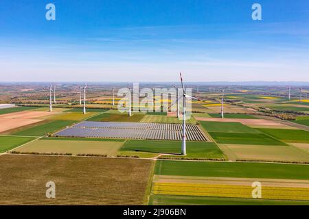 Stromerzeugung mit Windturbinen und Solarpark zwischen Feldern aus Drohnenperspektive Stockfoto