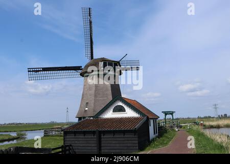 Die traditionelle Drainage-Windmühle De Woudaap in Countryside in Nordholland, Krommenie, Niederlande, Mai 2022 Stockfoto