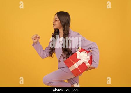 Shopper im Teenageralter. Beeil dich. stilvolle Teenager-Mädchen läuft mit Geschenkbox Stockfoto