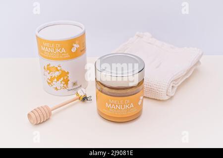 Manuka Honig in einem Glas mit gestempeltem Karton auf einem weißen Tisch Stockfoto