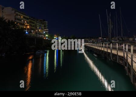 Freattyda, Athen - Griechenland - 12 28 2019 Seebrücke und Nachtlicht, das sich im Wasser spiegelt Stockfoto