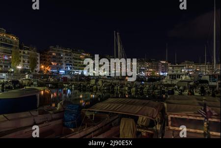 Freattyda, Athen - Griechenland - 12 28 2019 Seebrücke und Nachtlicht, das sich im Wasser spiegelt Stockfoto