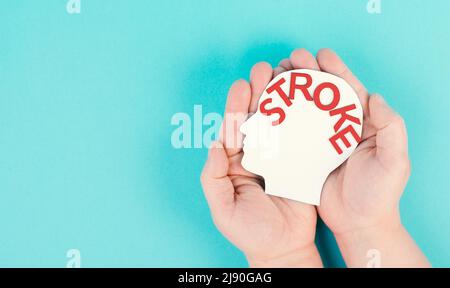 Einen Kopf mit dem Wort Schlaganfall in der Hand halten, Hirnverletzung, ischämische und hämorrhagische Typen, Gesundheitswesen Stockfoto