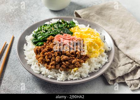 Hausgemachte japanische Sanshoku Don Chicken Rizschüssel mit Ei und Spinat Stockfoto