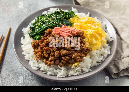 Hausgemachte japanische Sanshoku Don Chicken Rizschüssel mit Ei und Spinat Stockfoto