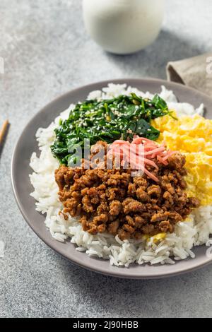 Hausgemachte japanische Sanshoku Don Chicken Rizschüssel mit Ei und Spinat Stockfoto