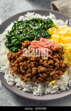 Hausgemachte japanische Sanshoku Don Chicken Rizschüssel mit Ei und Spinat Stockfoto