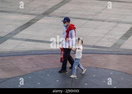 Changzhou, Jiangsu, China. 17.. Mai 2022. Ein älterer Mann und ein kleines Mädchen mit Gesichtsmasken als Vorsichtsmaßnahme gegen die Ausbreitung von covid-19 gesehen, die entlang der leeren Einkaufsstraßen in Jiangsu. (Bild: © Sheldon Cooper/SOPA Images via ZUMA Press Wire) Stockfoto