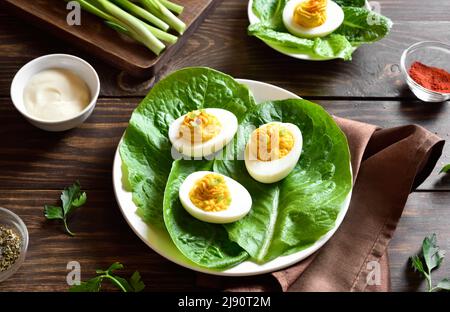 Auf dem Holzboden auf dem Teller devilierte Eier mit Paprika, Senf und Mayonnaise. Nahaufnahme Stockfoto