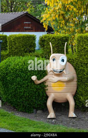 Wetzikon, Schweiz - 14. Mai 2022: Dekorative Figur eines lächelnden Großkäfers im Garten des Hauses Stockfoto