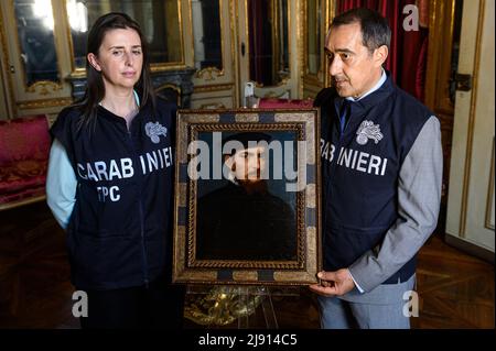 Turin, Italien. 19 Mai 2022. Das Gemälde "Portrait eines Gentleman in einer schwarzen Mütze" ("Ritratto di gentiluomo con berretto nero"), das Tizian (Tiziano Vecellio) zugeschrieben wird, wird von Mitgliedern der Carabinieri der Denkmalschutzeinheit von Turin während der Rückgabe an den italienischen Staat gehalten. Das Kunstwerk war von 2003 bis 2020 verschwunden und wurde von den Carabinieri der Abteilung zum Schutz des Kulturerbes von Turin gefunden, dessen Wert auf etwa 7 Millionen geschätzt wird. Kredit: Nicolò Campo/Alamy Live Nachrichten Stockfoto