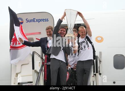 19. Mai 2022, Hessen, Frankfurt/Main: Europa League, nach Eintracht Frankfurts Finalsieg gegen die Glasgow Rangers in Sevilla. Der Frankfurter Cheftrainer Oliver Glasner und Sebastian Rode (r) feiern mit der Trophäe, als sie das Flugzeug am Frankfurter Flughafen verlassen. Foto: Thomas Frey/dpa Stockfoto