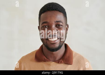 Porträt eines fröhlich hübschen jungen afroamerikanischen Mannes mit Bart und Pullover Stockfoto