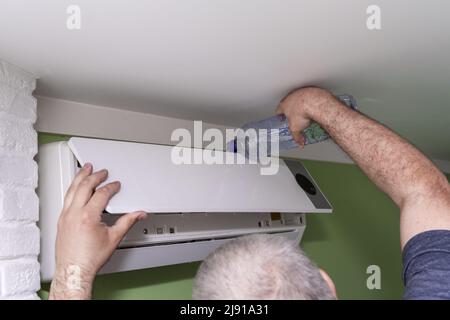 Männliche Techniker Reinigung Klimaanlage im Innenbereich Stockfoto