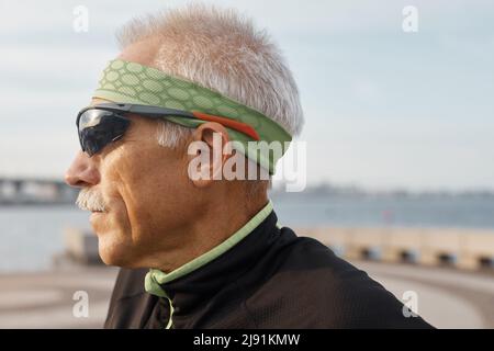 In der Nähe der horizontalen Seite Portraitfotos der Kaukasischen alter Mann tragen sportliche Sonnenbrille ausführen Stockfoto