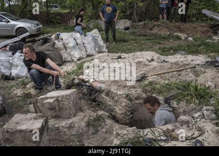 Malaya Rohan, Ukraine. 19.. Mai 2022. Am Donnerstag, den 19. Mai 2022, ziehen Männer die Leichen von zwei toten russischen Soldaten heraus, von wo aus er in einem Personenfronthof in Mala Rohan, Ukraine, begraben wurde. Mala Rohan ist ein kleines Dorf, das von den ukrainischen Truppen nach dem Angriff Russlands auf die Ukraine zurückgenommen wurde. REDAKTEURE NOTIEREN DEN INHALT. Foto von Ken Cedeno/UPI Credit: UPI/Alamy Live News Stockfoto