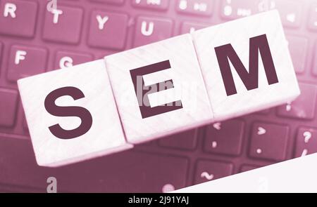 SEM Search Engine Marketing auf einem hölzernen Würfel geschrieben, der auf Computertastatur gesetzt wird. Optimierung Online Business Technologie Konzept Stockfoto