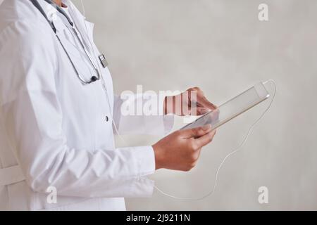 Horizontales Mittelteil-Studioporträt der modernen Ärztin mit digitalem Tablet zur Arbeit Stockfoto