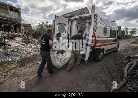 Malaya Rohan, Ukraine. 19.. Mai 2022. Die Leiche eines toten russischen Lots wird in einen Krankenwagen gelegt und wartet auf zwei weitere, nachdem sie am Donnerstag, den 19. Mai 2022, auf dem Völkerhof in Mala Rohan, Ukraine, ausgegraben wurden. Mala Rohan ist ein kleines Dorf, das von den ukrainischen Truppen nach dem Angriff Russlands auf die Ukraine zurückgenommen wurde. Foto von Ken Cedeno/UPI Credit: UPI/Alamy Live News Stockfoto