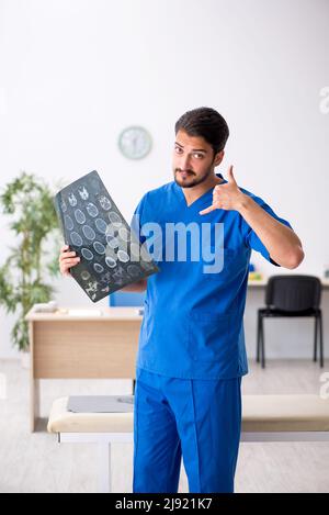 Junger Radiologe, der in der Klinik sitzt Stockfoto