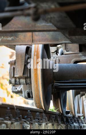 Nahaufnahme der alten rostigen Räder des Zuges. Eisenbahnwaggons auf Schiene. Stockfoto
