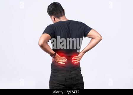 Menschen mit Wirbelsäulenproblemen, Mann mit Rückenproblemen auf isoliertem Hintergrund, Konzept mit Lendenwirbelproblemen, ein wund Mann mit Rückenschmerzen Stockfoto