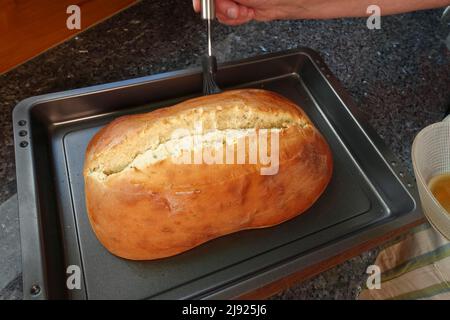 Schwäbische Küche, Zubereitung Ulmer Zuckerbrot, süßer Hefe Hefeteig mit Fenchelsamen, gebacken, Brot mit Rosenwasser aufstreuen, Bürste Stockfoto