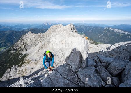 Wanderer auf einem gesicherten Weg, Aufstieg zum Mitterhorn, steile felsige Berglandschaft, Felskamm mit Gipfeln des Großen Rothorns und des Östlichen Rothorns im Stockfoto