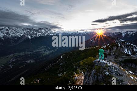 Sonnenuntergang, junger Wanderer am Kramerspitz, Wettersteingebirge und Zugspitze im Hintergrund, Bayern, Deutschland Stockfoto