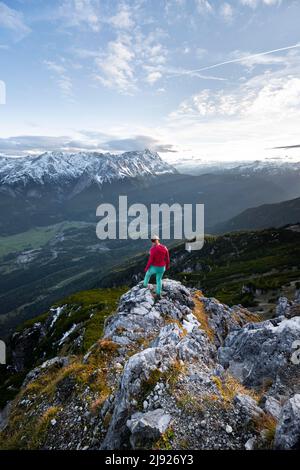 Junger Wanderer am Kramerspitz, Wettersteingebirge und Zugspitze im Hintergrund, Bayern, Deutschland Stockfoto