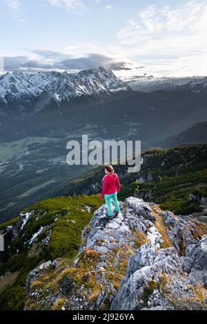 Junger Wanderer am Kramerspitz, Wettersteingebirge und Zugspitze im Hintergrund, Bayern, Deutschland Stockfoto