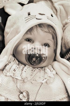 Sepia-Farben, Porträt einer alten dekorativen Babypuppe, Kinderspielzeug, Symbolbild, Österreich Stockfoto