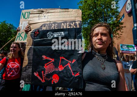 Rotterdam, Niederlande, 19/05/2022, Während der Demonstration wird eine Frau mit einem Plakat gegen den Klimawandel gesehen. Mit diesem Protest startete die Klimaorganisation Extinction Rebellion (XR) eine Kampagne, um ein Ende der fossilen Industrie und einen klimafreundigen Übergang zu fordern. Hunderte von Aktivisten versammelten sich am Hauptbahnhof von Rotterdam und marschierten von dort aus durch die Stadt, darunter mehrere künstlerische Darbietungen. Diese Kampagne dauert bis zum 24.. Mai und wird auf mehrere disruptive Aktionen und Workshops zählen, um Notfallmaßnahmen gegen das Klima und die ökologische cr zu fordern Stockfoto