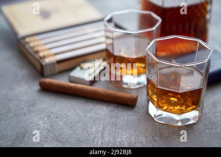 Karaffe von Whiskey oder Brandy, Brille und Schachtel finnest kubanischer Zigarren Stockfoto