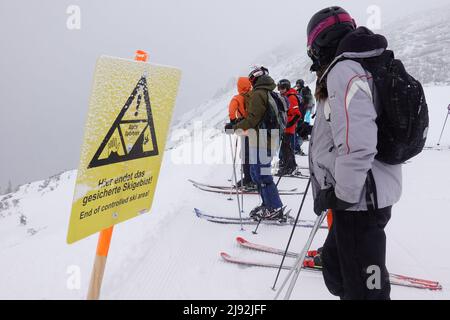 03.02.2022, Obertraun, Oberösterreich, Österreich - Skifahrer steht am Ende des gesicherten Skigebietes. 00S220203D736CAROEX.JPG [MODEL RELEASE: NO, PROPERTY RE Stockfoto