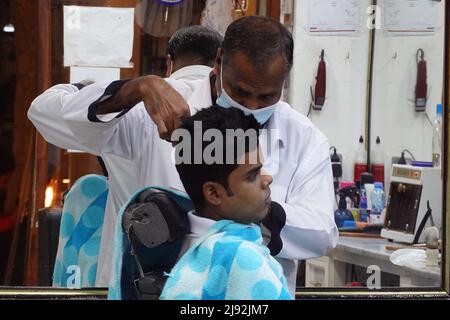 22.02.2022, Doha, , Katar - Jugend, die sich von einem Friseur die Haare schneiden lässt. 00S220222D372CAROEX.JPG [MODEL RELEASE: NO, PROPERTY RELEASE: NO (c) caro images / Stockfoto