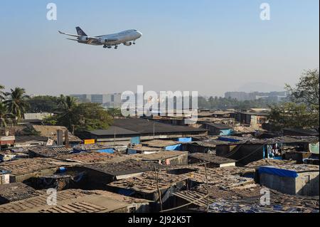 10.12.2011, Mumbai, Maharashtra, Indien - Ein U.S. United Parcel Service (UPS) Boeing 747-400F Frachtflugzeug auf Annäherung über die Dächer einer Shantytown zu Stockfoto