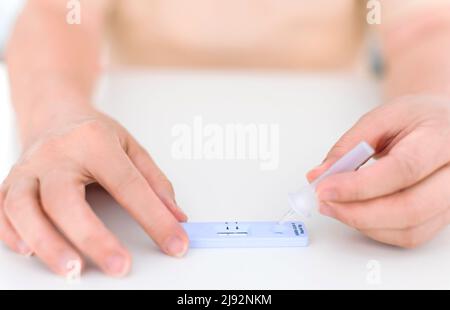 Frau, die das Coronavirus Covid-19 Rapid Antigen-Testkit verwendet Stockfoto