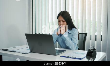 Junge asiatische Frauen sind besorgt oder gestresst über die Arbeit im Unternehmensbüro. Stockfoto