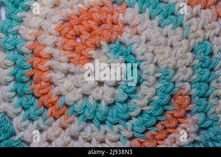 Nahaufnahme abstrakter Textur Hintergrund aus elegantem gehäkeltem Stoff mit rosa, blau und weißem Garn Stockfoto