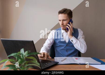 Foto erfolgreiche fokussierten Mann mit Bart und nutzt moderne digitale intelligente Gerät reden, chatten in sozialen Netzwerken, Tastaturen auf einem Laptop-Computer, Nachrichten auf Websites lesen, arbeiten in einem Büro Stockfoto