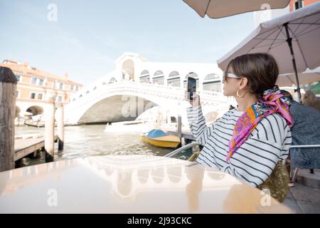 Frau, die im Café im Freien in Venedig, Italien, fotografiert Stockfoto