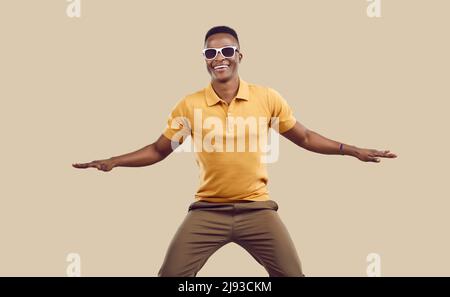 Glücklich attraktiven afrikanischen Mann in lässiger Kleidung tanzen und Spaß im Modestudio Stockfoto